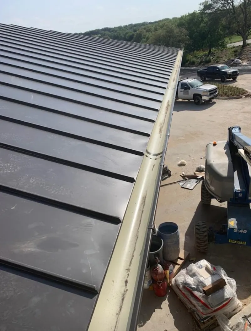 Standing seam panel and gutter detail on a metal roofing jobsite in Lewisville